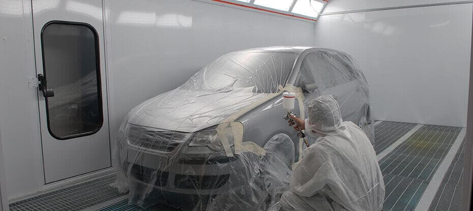 Person in PPE painting car